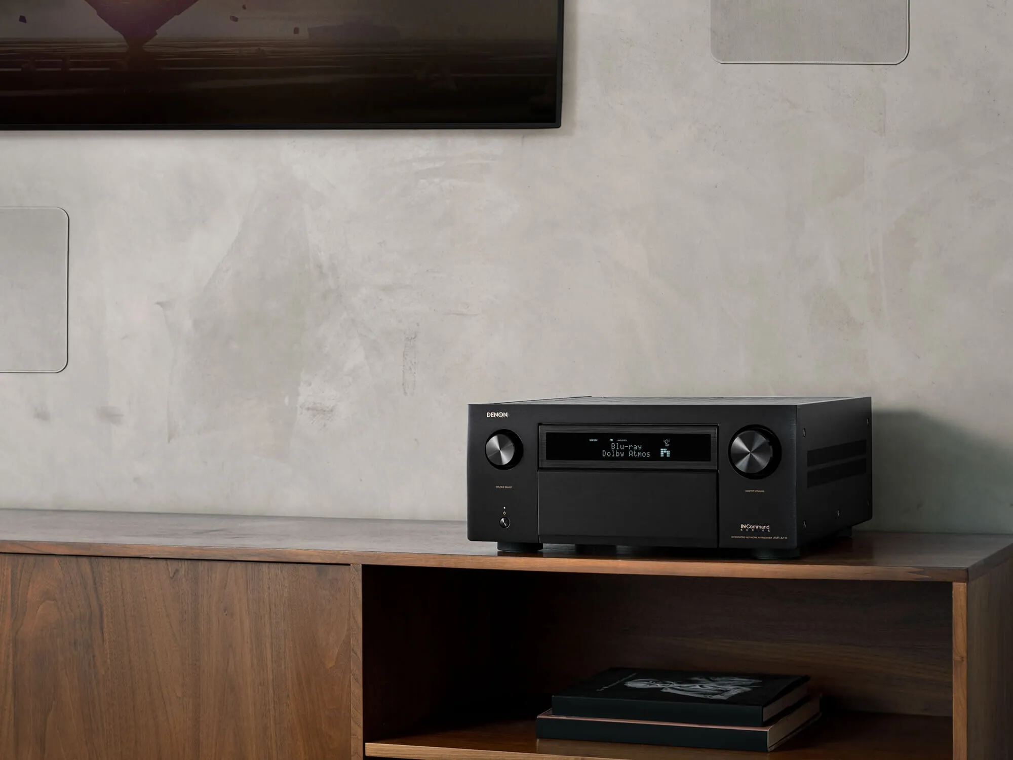 Denon AVC-A1H sobre un mueble de madera en un living con televisor