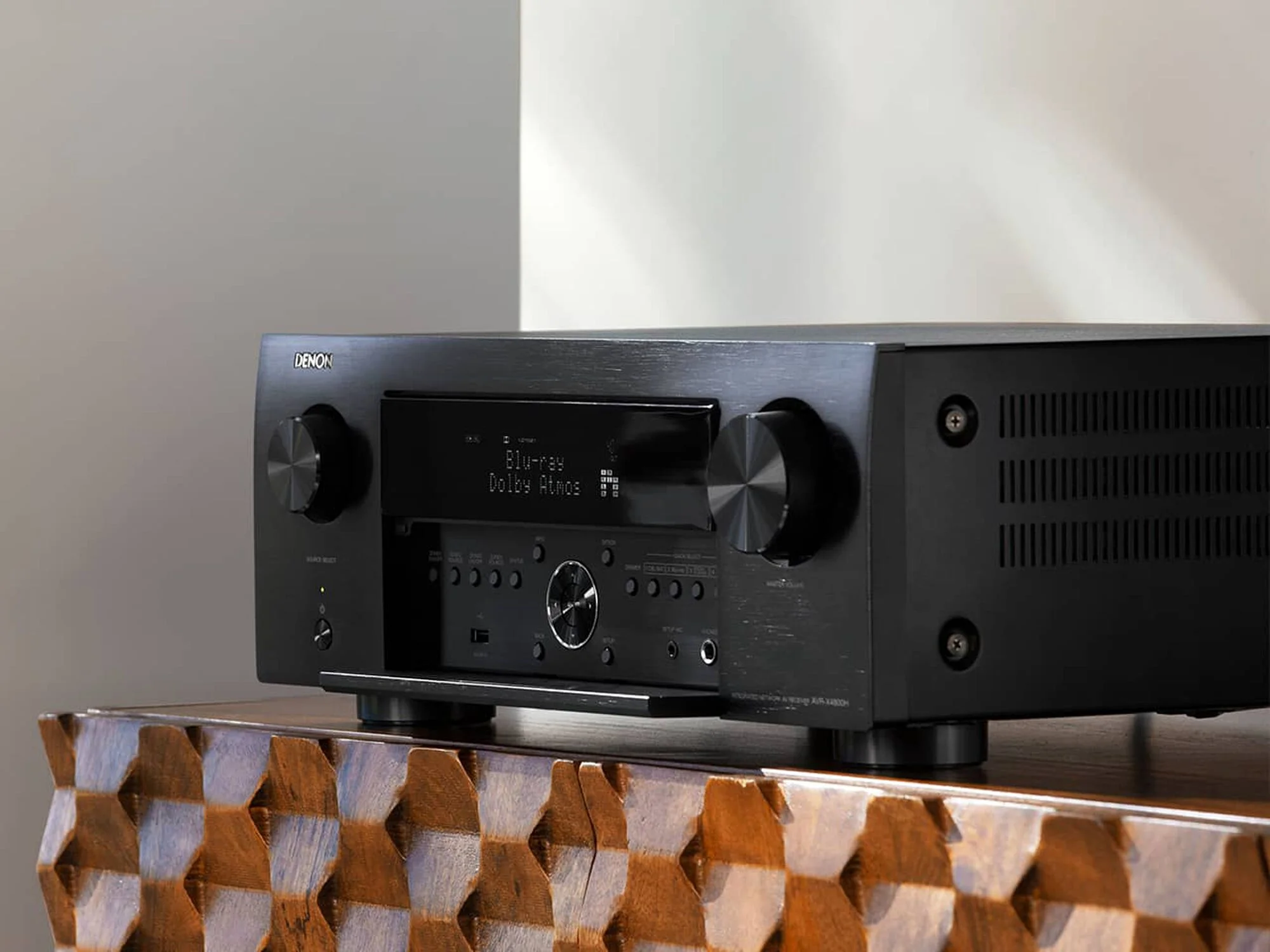 Amplificador de cine en casa Denon AVC-X4800H en vista lateral sobre un mueble del living