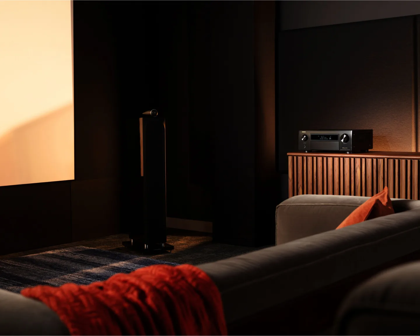 Amplificador de cine en casa Denon AVC-X6800H junto a bafles de piso en el living