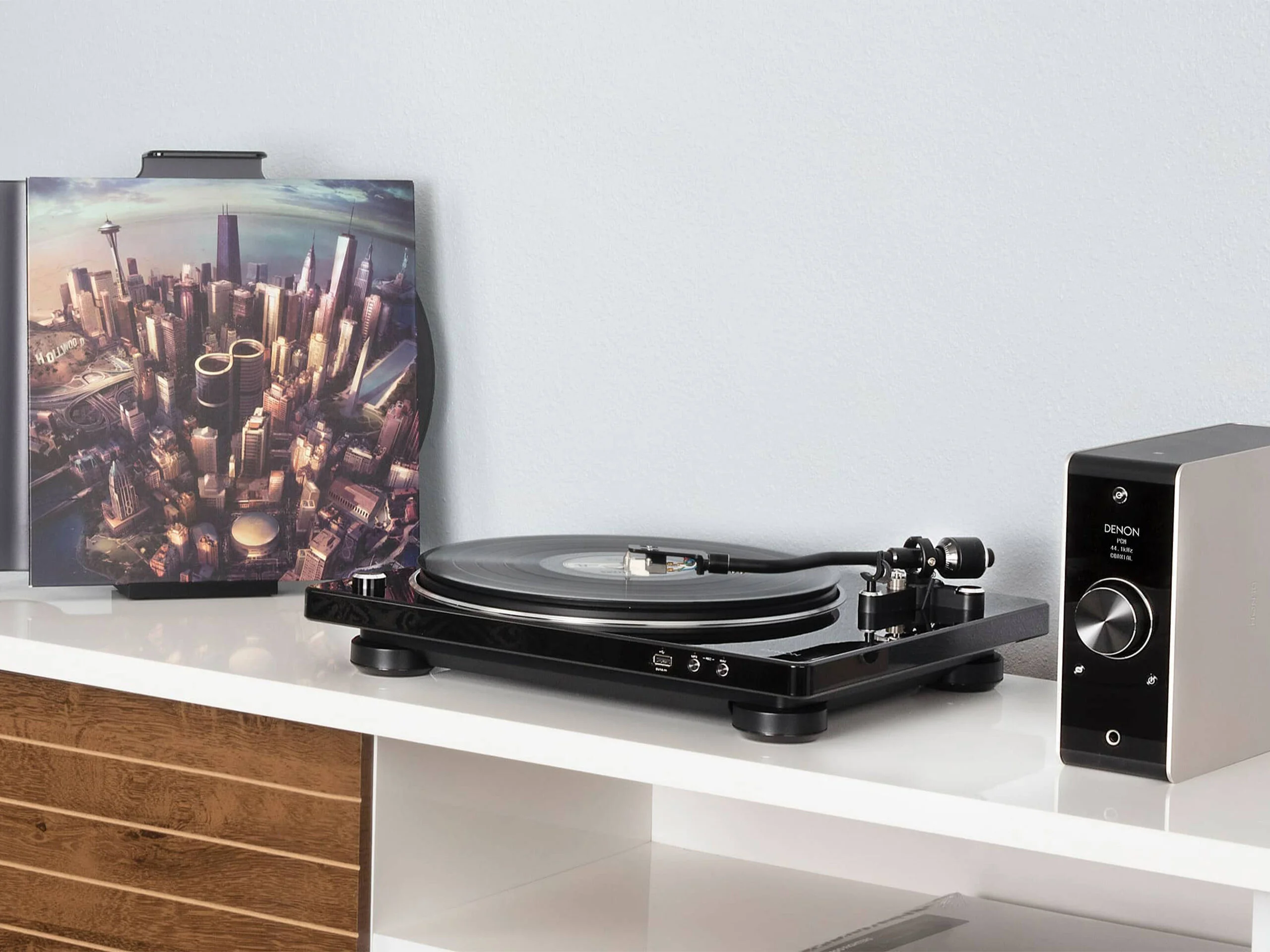 Bandeja giradiscos Denon DP-450USB en un mueble junto a un amplificador Denon
