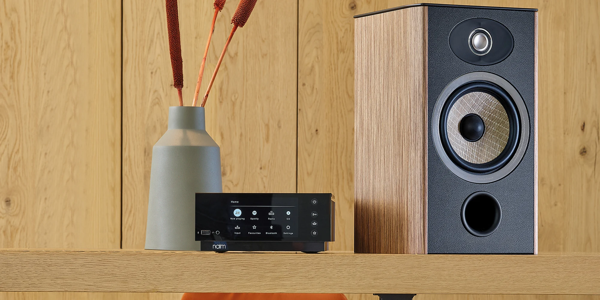 Bafle de estante Focal Aria Evo X N1 sobre un mueble junto a un streamer